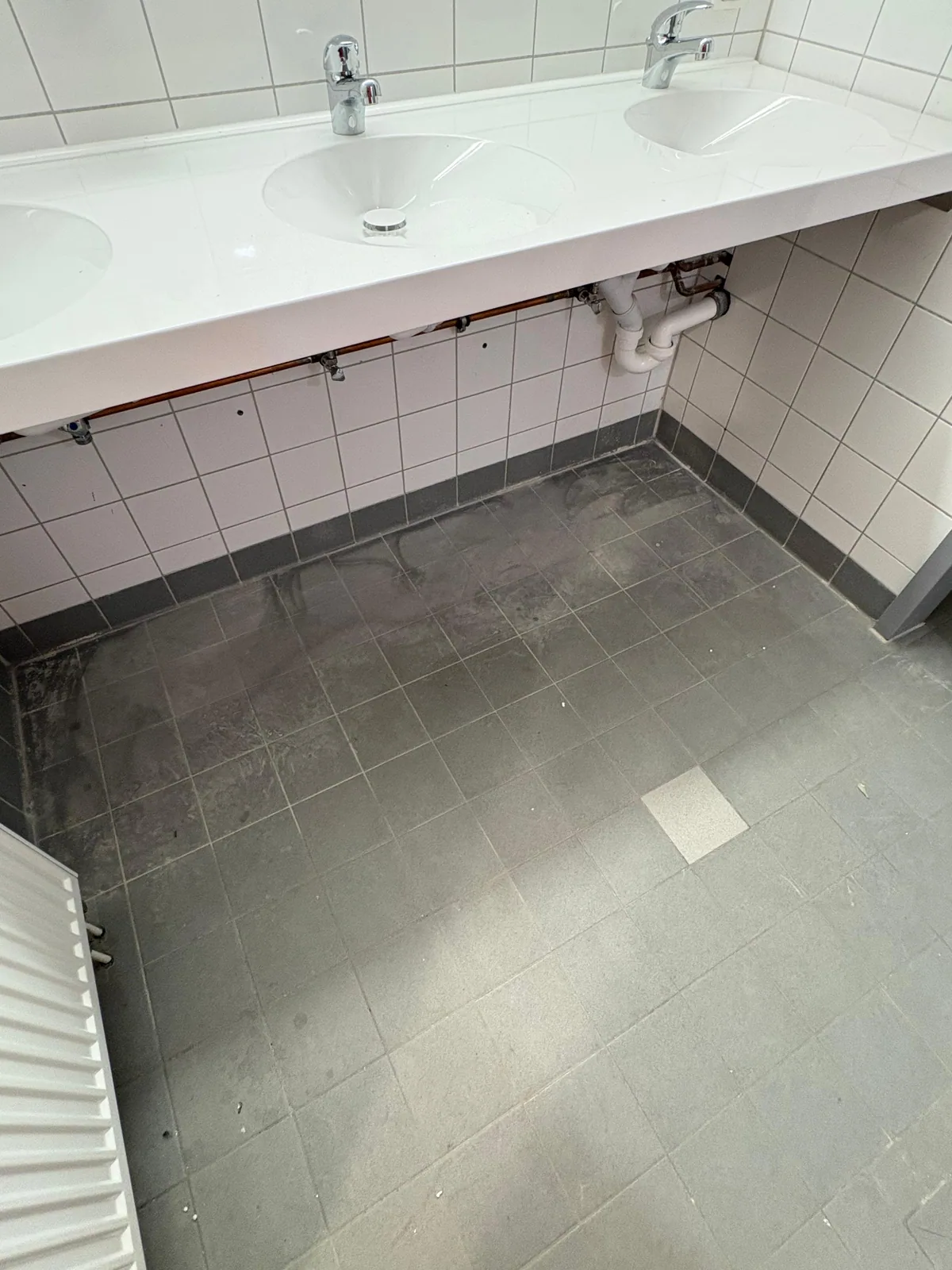 Waschbecken und staubiger Bodenbelag vor der Endreinigung