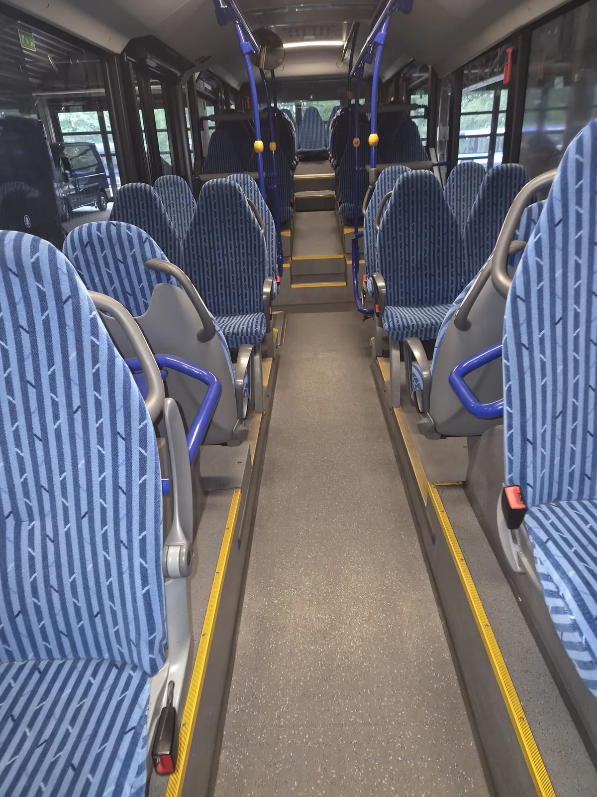 Gereinigter, aber noch unbeschichteter Bodenbelag im Mittelgang eines Linienbusses, matte Oberfläche