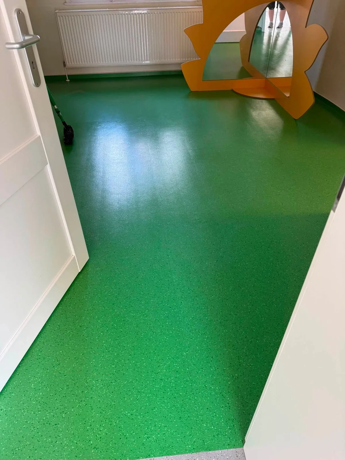 Grüner Bodenbelag nach der Grundreinigung, gleichmäßig glänzend