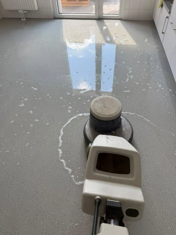 Reinigungsmaschine auf einem grauen Bodenbelag im Sonnenlicht