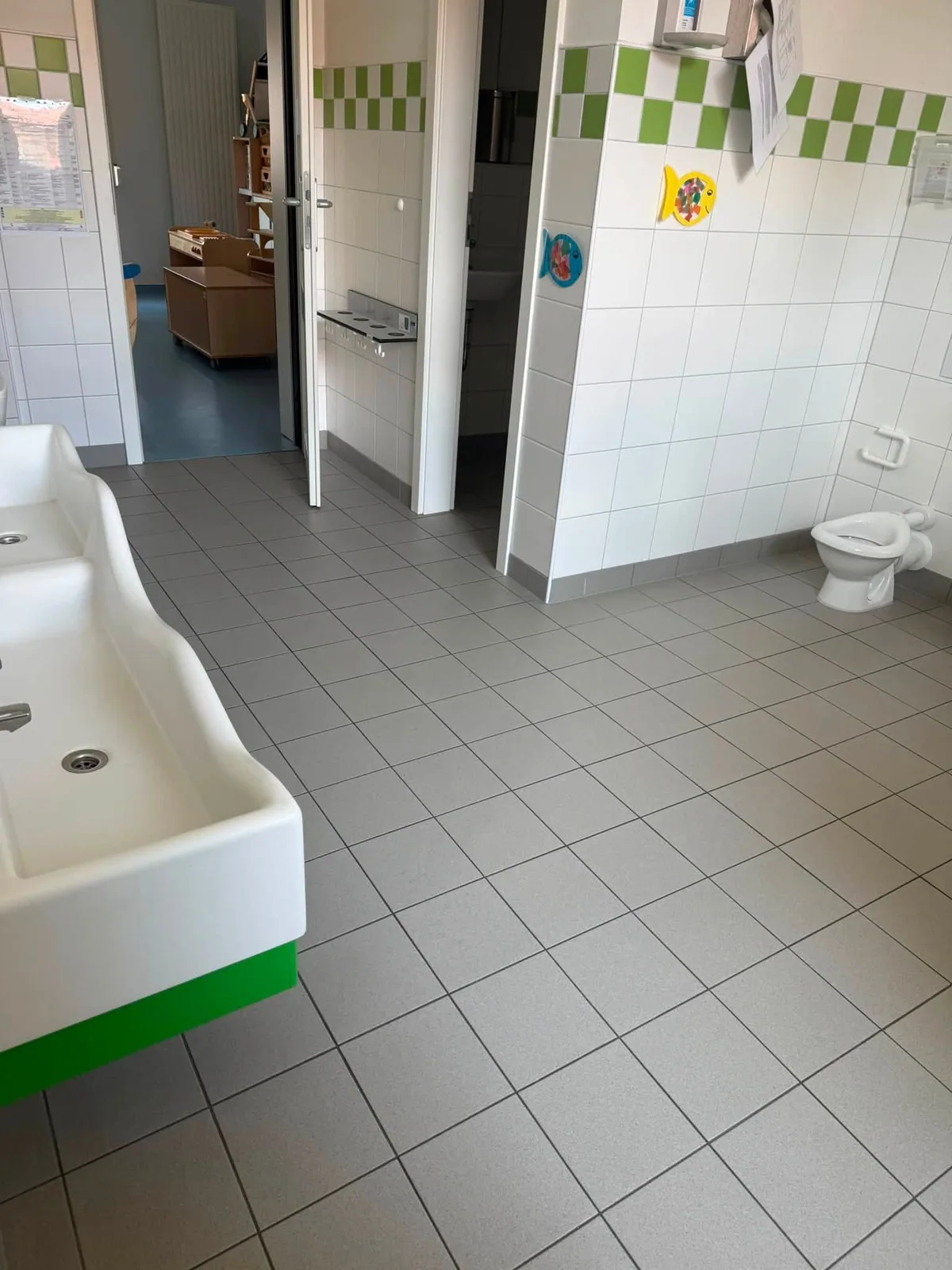 Gereinigter Sanitärbereich mit Waschbecken und Fliesenboden