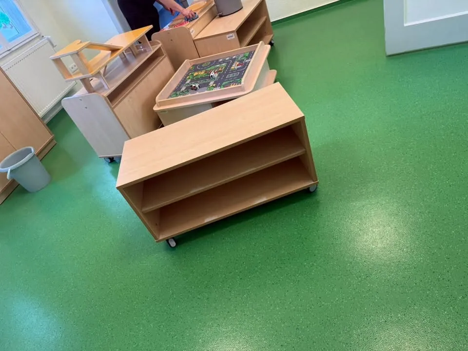 Gereinigter grüner Bodenbelag, ein Möbelwagen wird zurückgeschoben