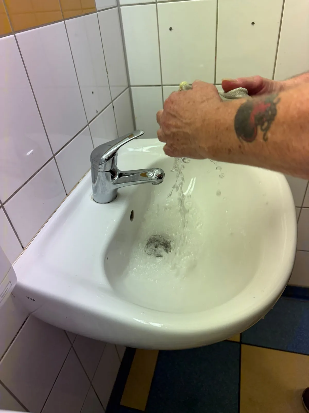 Ein Reinigungstuch wird unter fließendem Wasser ausgewaschen